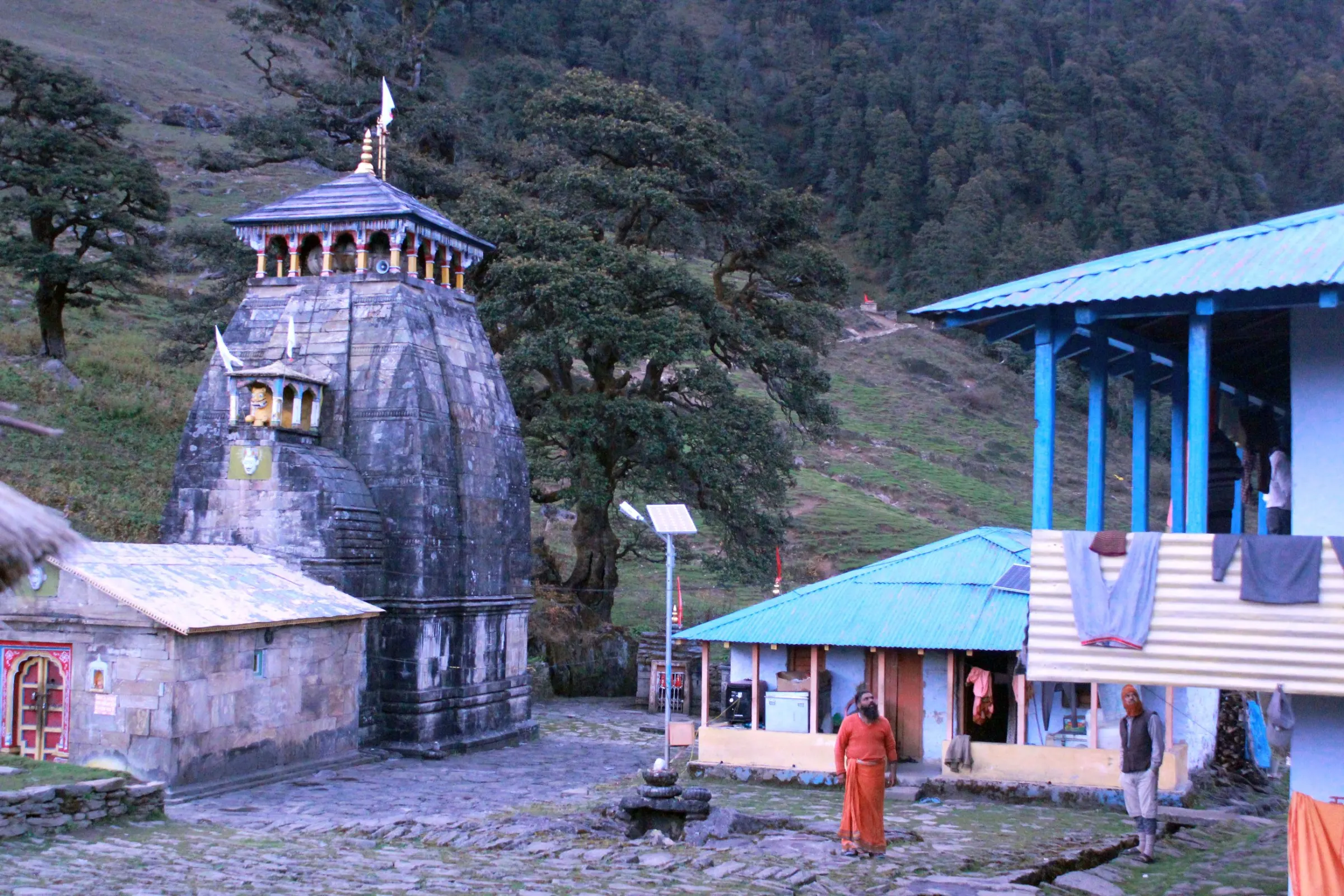 Trekkers at the Madhyamaheshwar temple with Chaukhamba behind