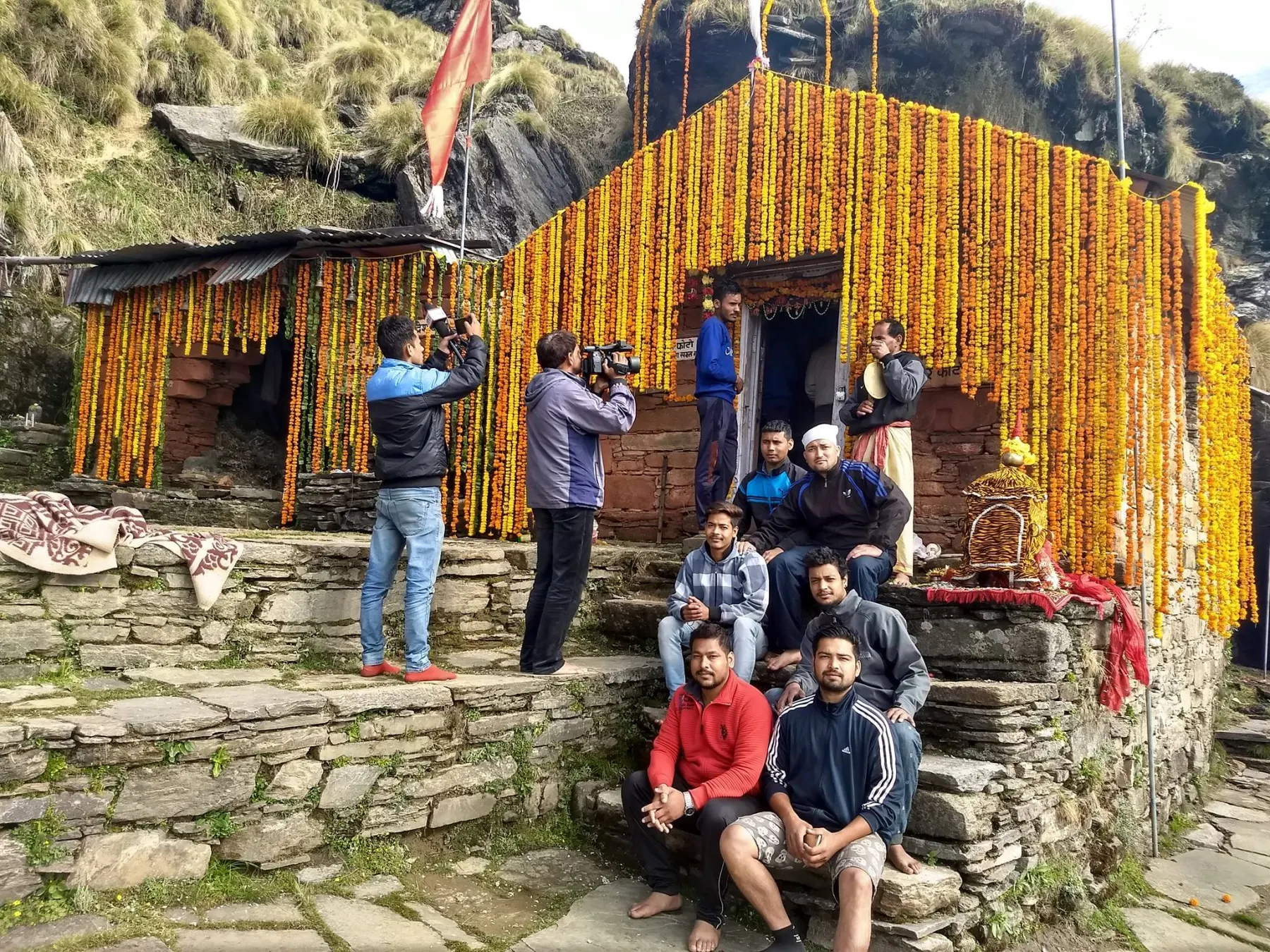 Trekkers approaching the Rudranath temple across its meadow